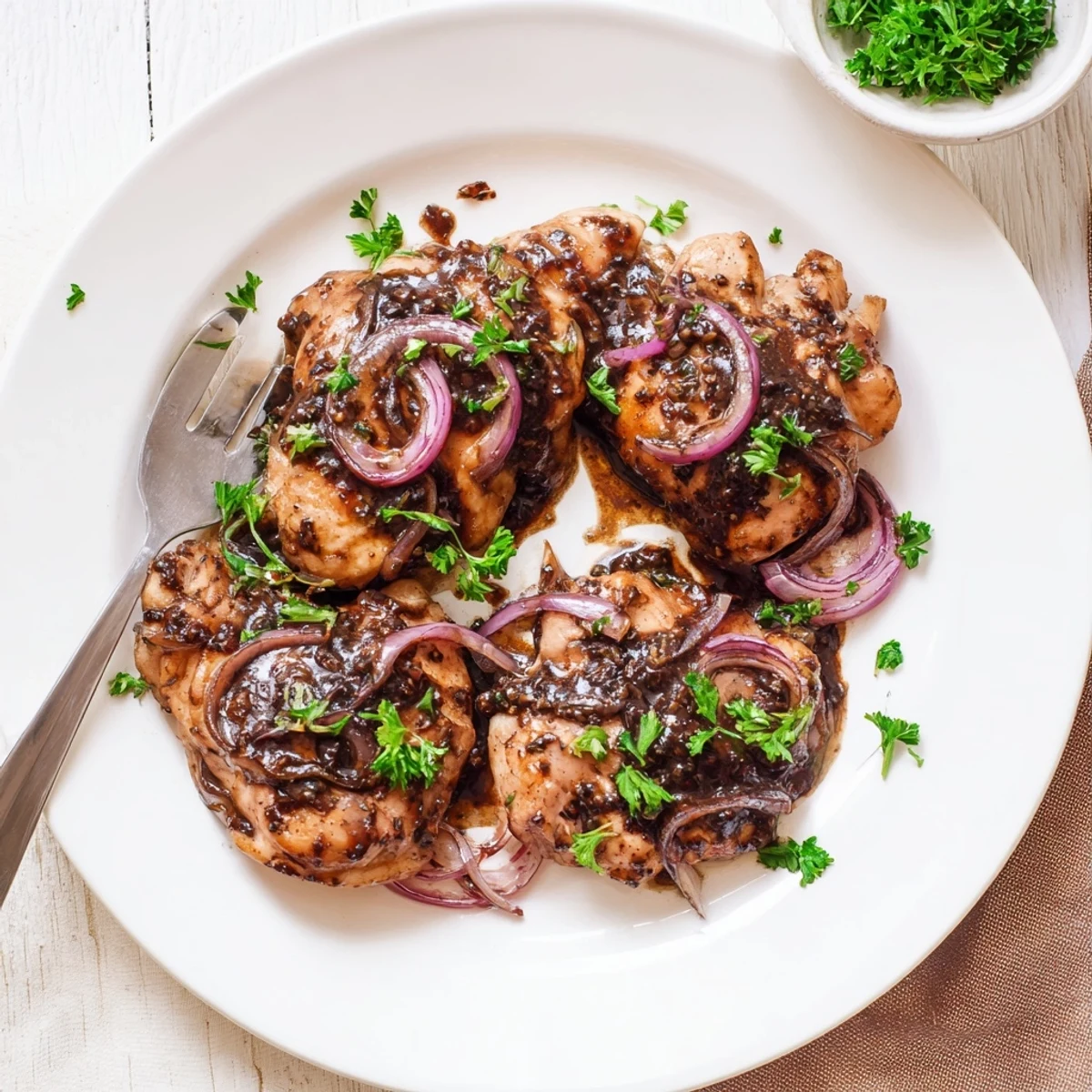 Golden brown slow cooker balsamic chicken thighs glazed in rich dark tangy sauce