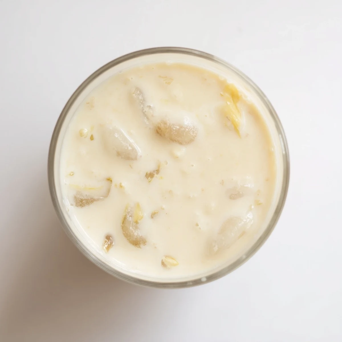 Creamy durian smoothie blended with coconut milk and banana, garnished with tropical fruit in a chilled glass