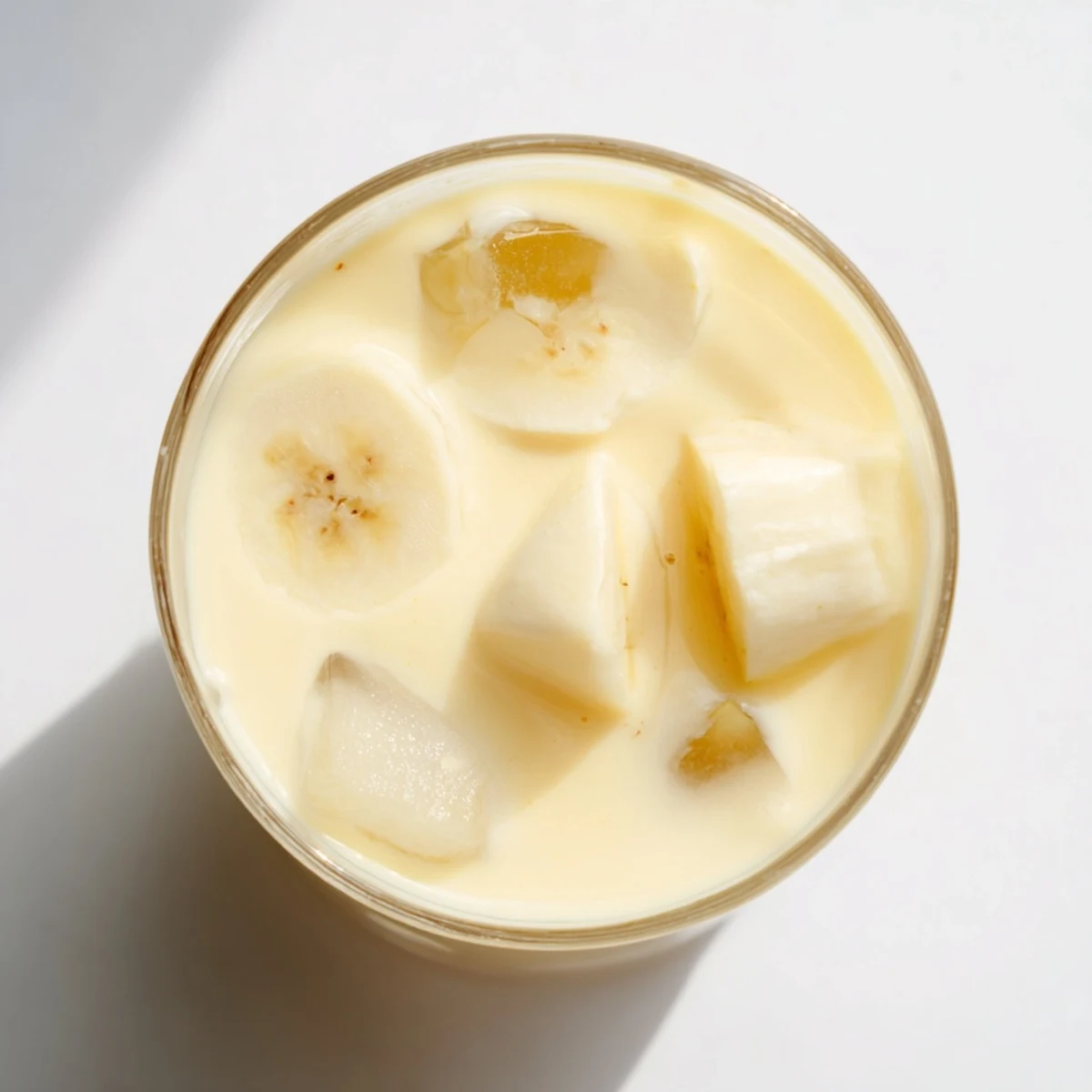 Thick tropical durian smoothie featuring ripe durian flesh, banana, and ice topped with coconut flakes