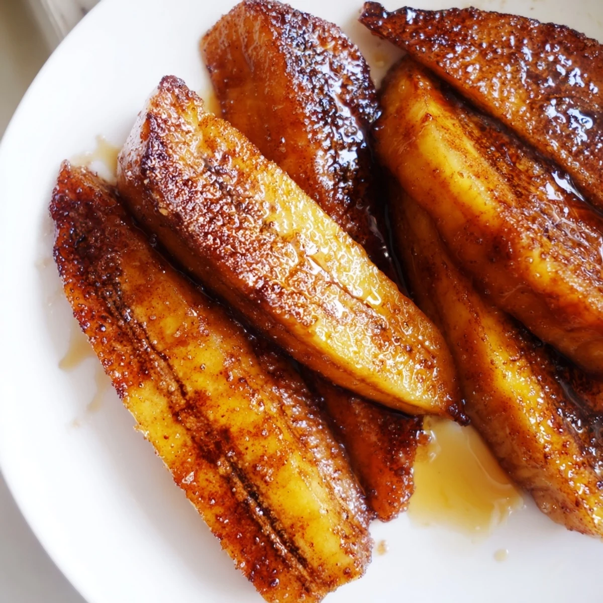 Golden pan fried cinnamon bananas sizzling in butter with brown sugar caramelization