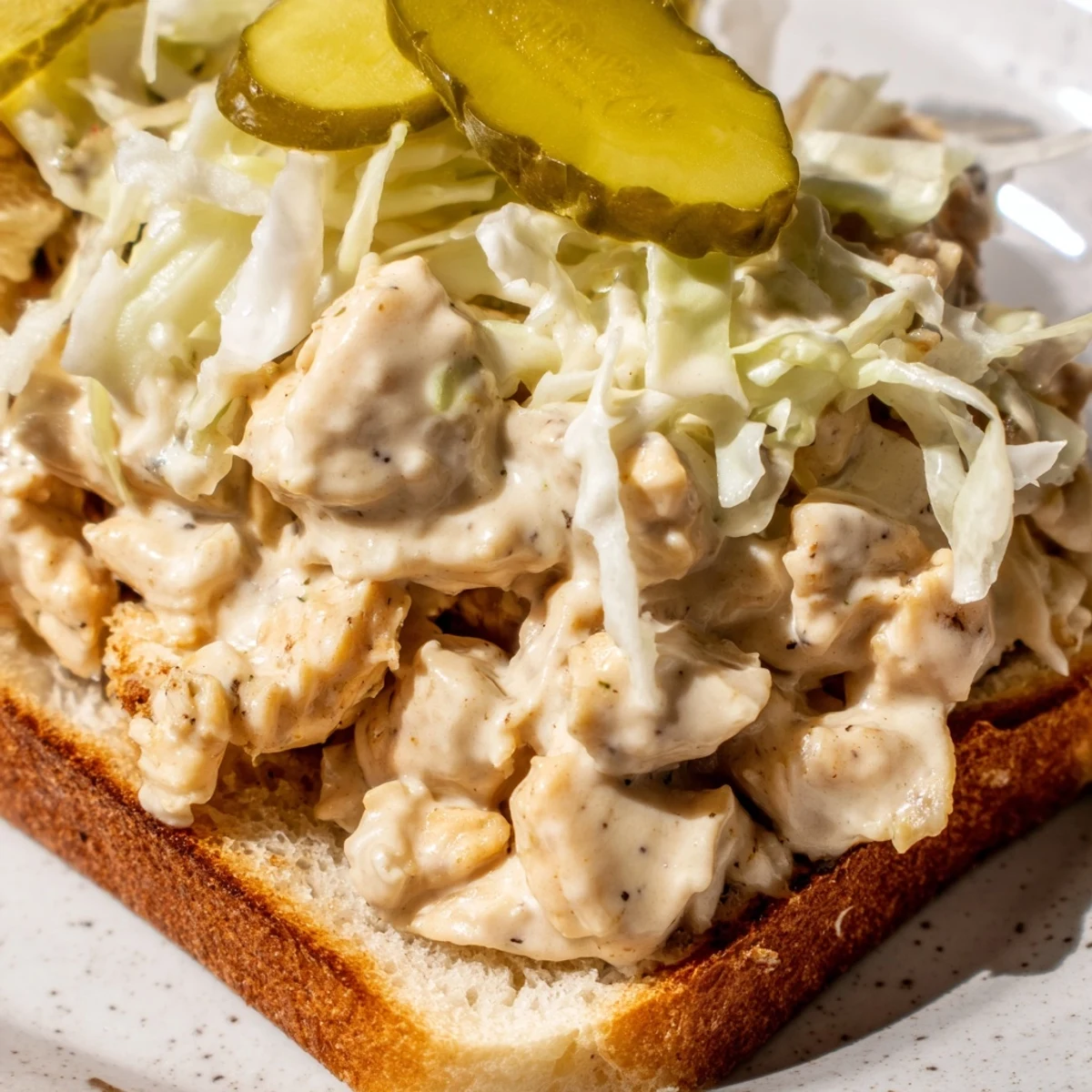 Tender chopped chicken breast coated in tangy Alabama white BBQ sauce topped with crunchy coleslaw