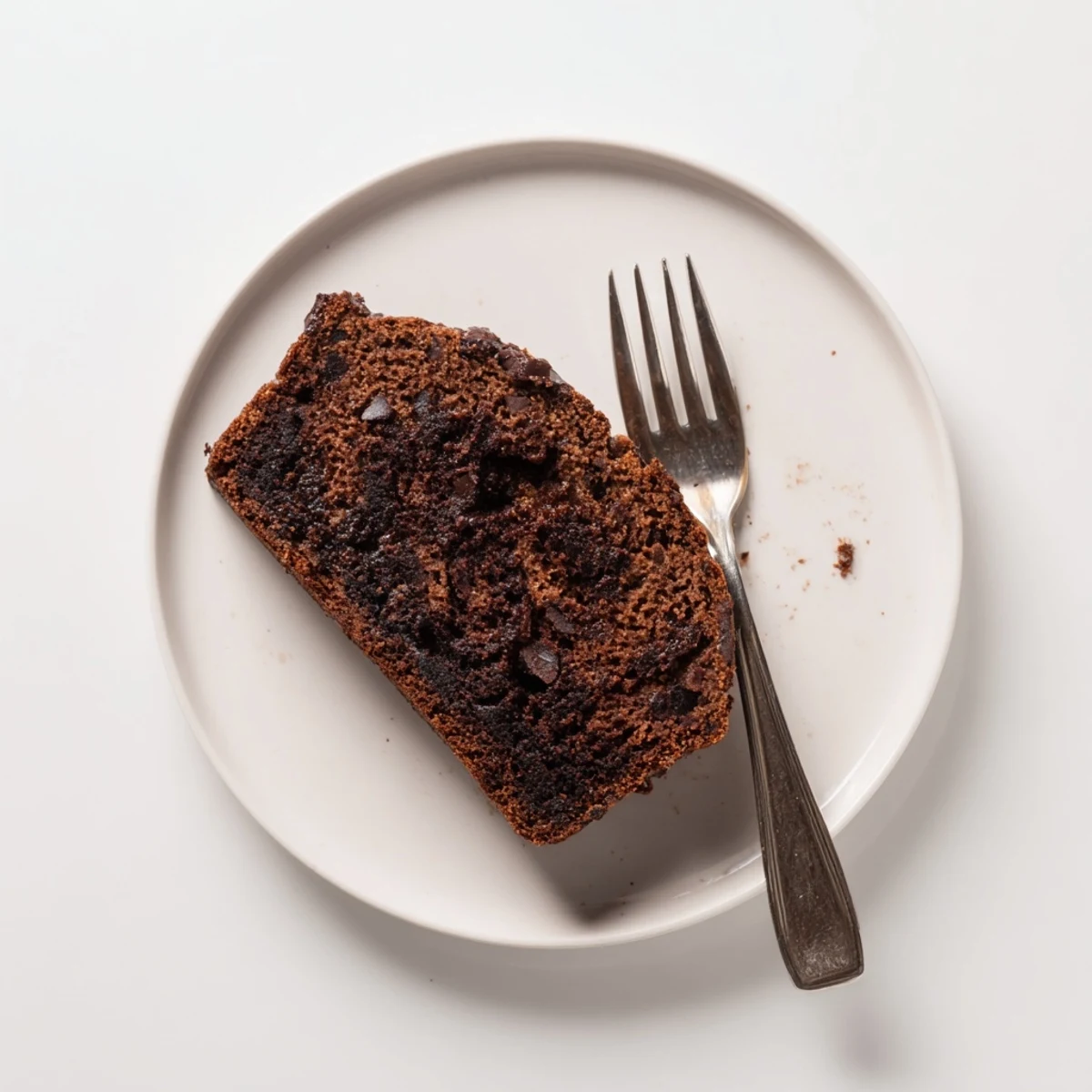 Freshly baked chocolate espresso banana bread loaf studded with melted chocolate chips and dusted with cocoa powder