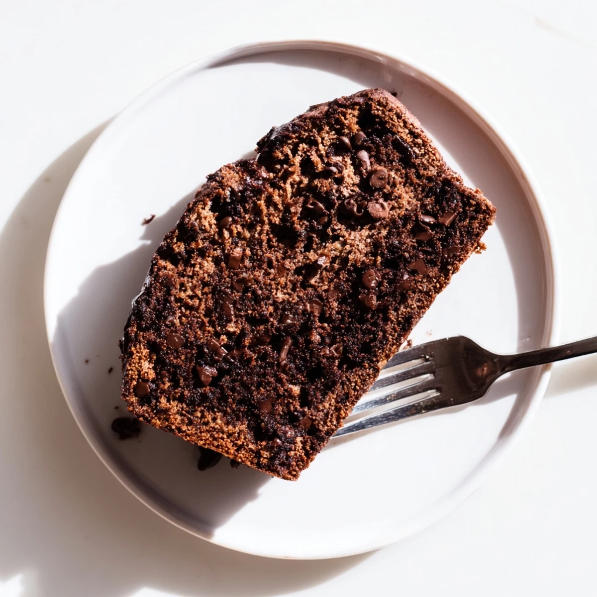 Warm chocolate espresso banana bread served on a wooden board with a pat of melting butter