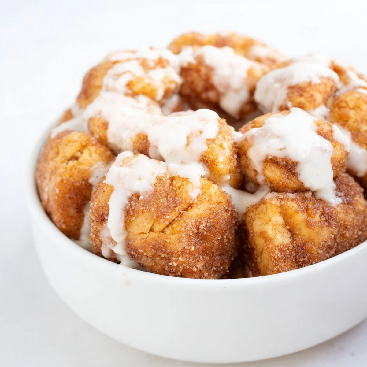 Warm pull-apart monkey bread drizzled with vanilla glaze showing fluffy high protein pieces in a ring