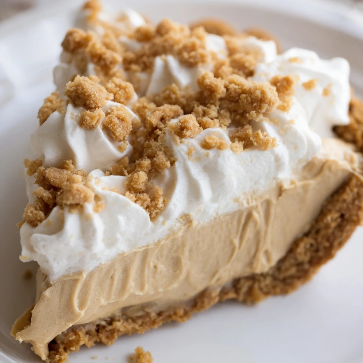 Creamy Amish Peanut Butter Dream Pie topped with fluffy whipped cream and golden crumbs