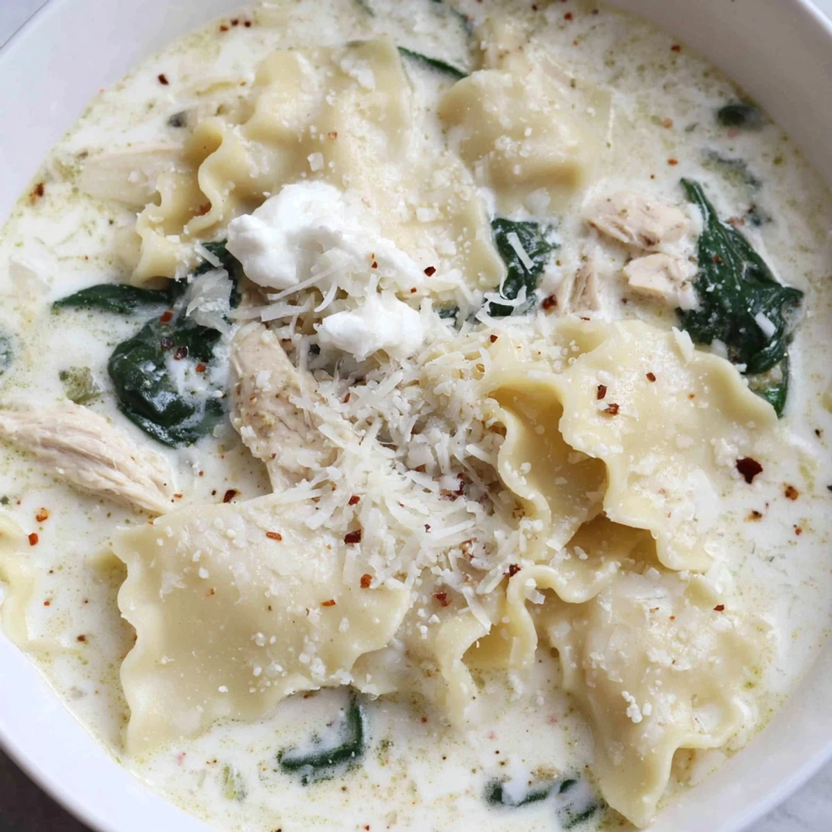 Steaming bowl of white lasagna soup with melted mozzarella and broken noodles