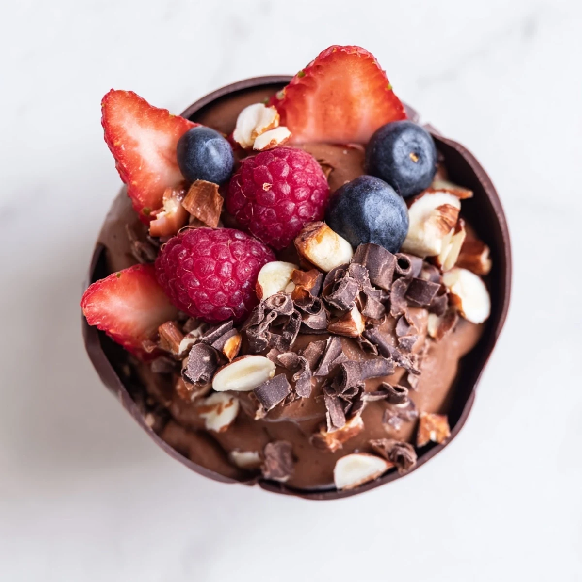 Elegant chocolate grazing cups with glossy mousse, jewel toned berries, and crunchy nut garnish