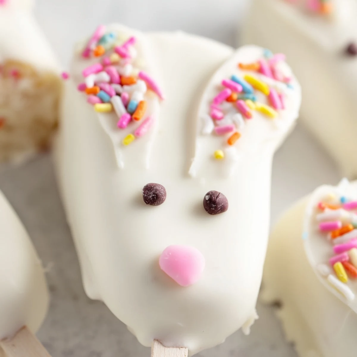 Adorable white chocolate bunny cakesicles with candy eyes on sticks for Easter celebrations