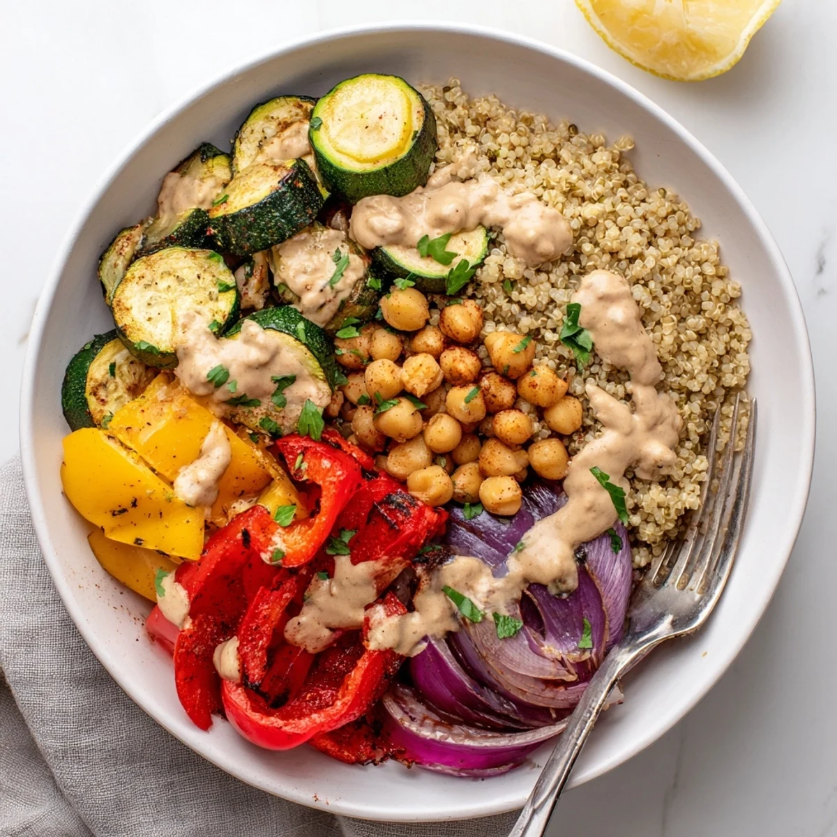 Golden roasted zucchini, eggplant, and chickpeas in a vegan Mediterranean roasted vegetables bowl drizzled with creamy tahini dressing.
