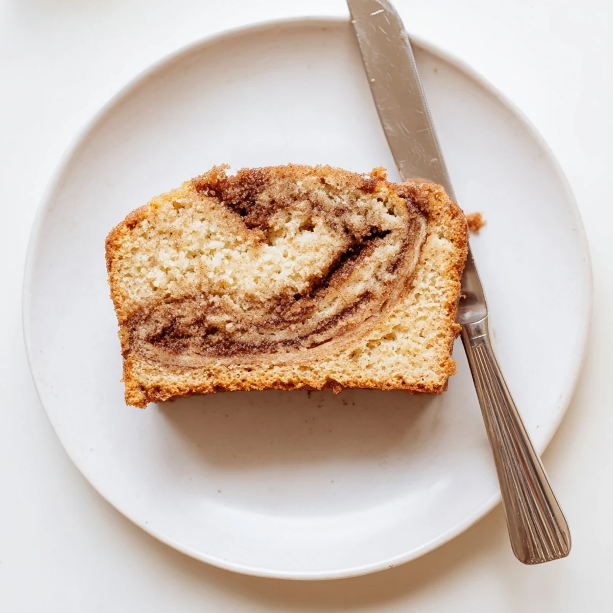 Warm snickerdoodle banana bread loaf topped with crackly cinnamon sugar and sliced