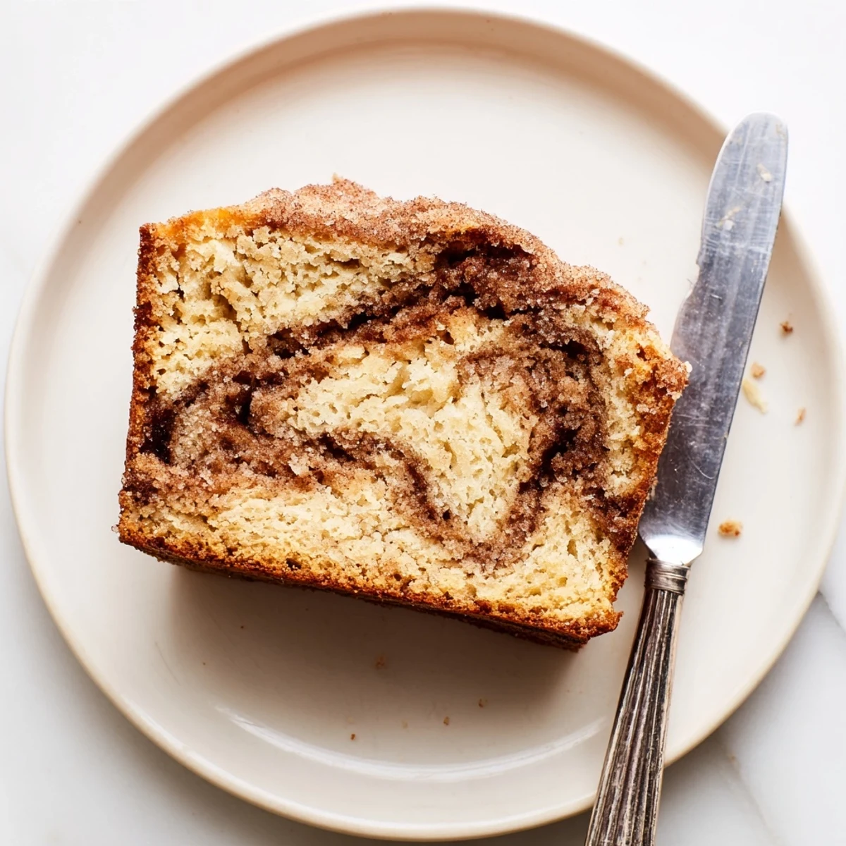 Thick slice of snickerdoodle banana bread showing a marbled cinnamon-sugar center