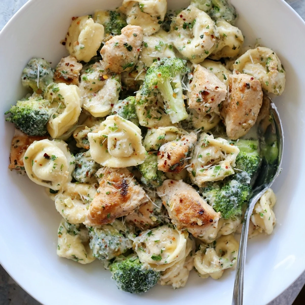 Skillet-ready Creamy Garlic Parmesan Tortellini Chicken Broccoli Recipe with bright green florets