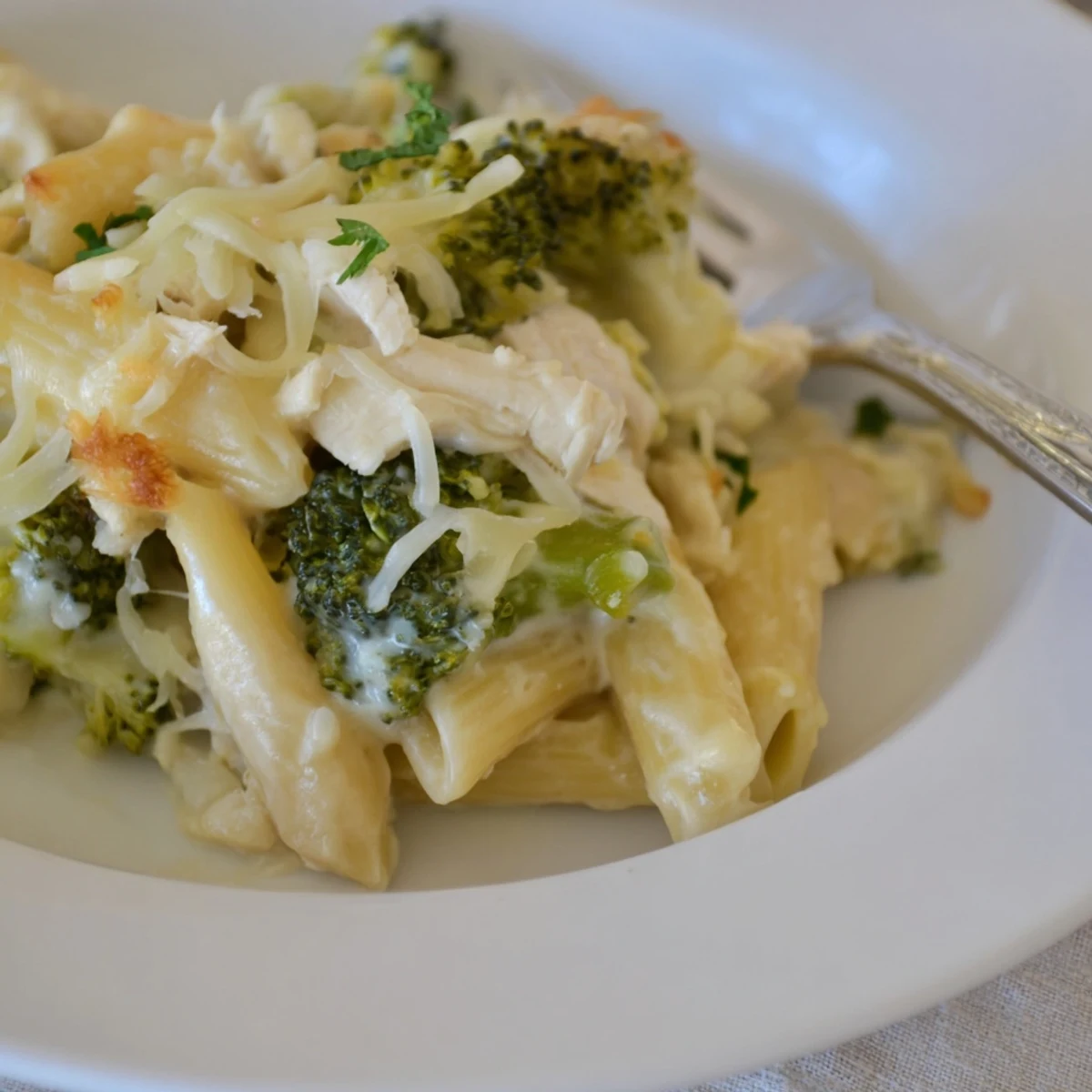 Creamy Chicken Broccoli Alfredo Bake served hot with garlic bread nearby