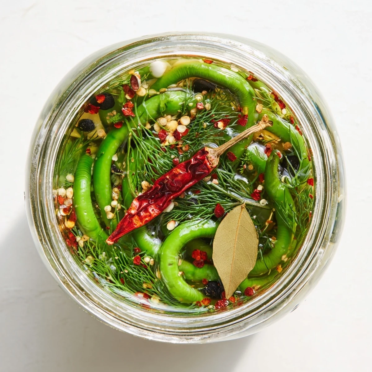 Close-up of crunchy spicy pickled garlic scapes in clear brine ready for charcuterie boards