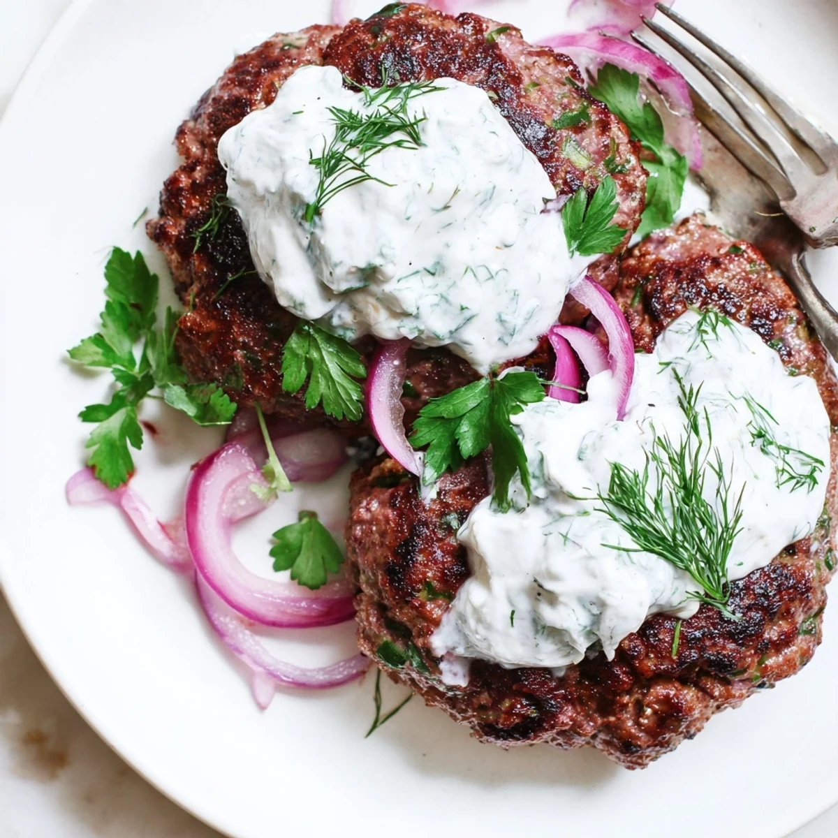 Golden brown smashed beef kebabs sizzling on a grill pan with charred edges