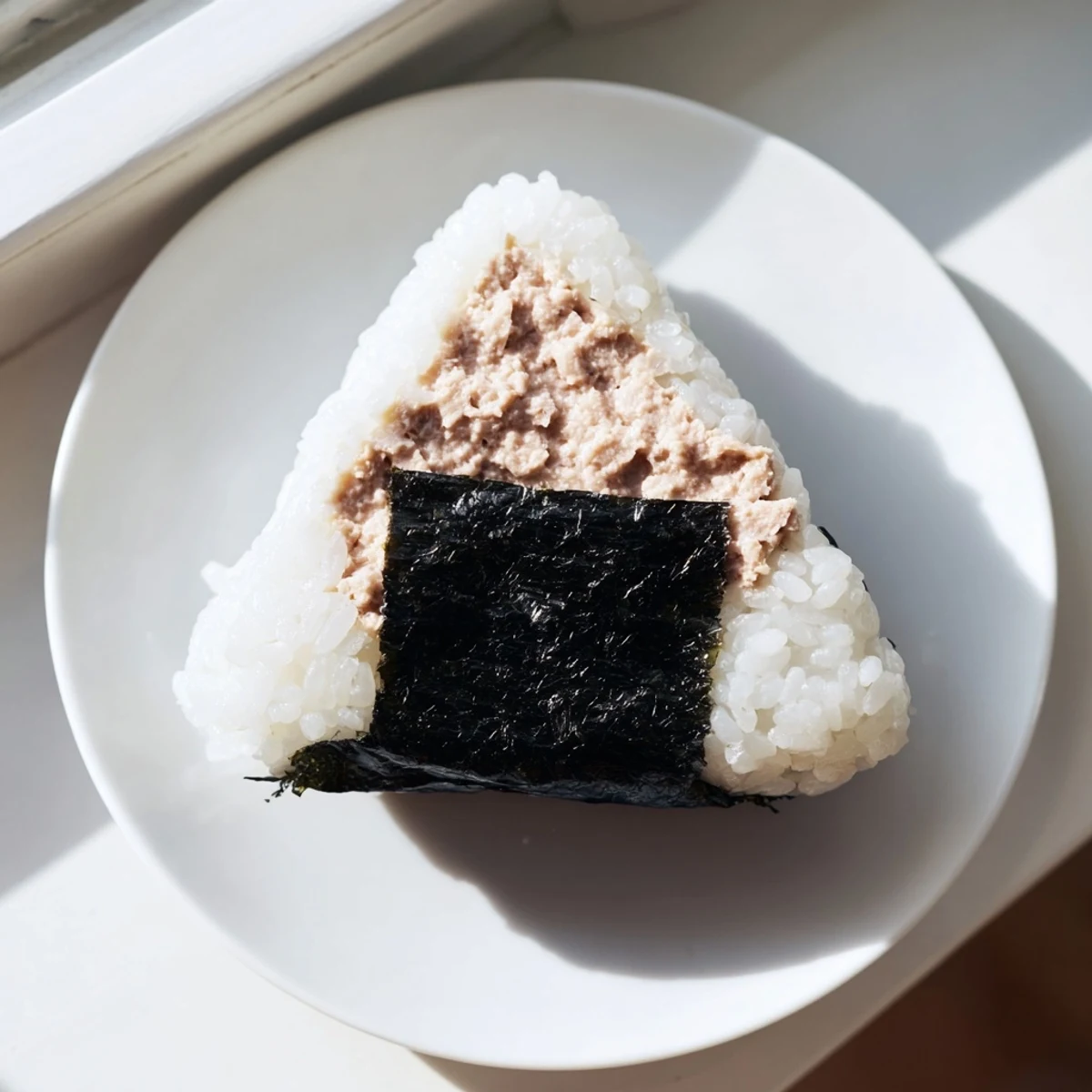 Golden triangle-shaped tuna mayo onigiri wrapped in crisp nori seaweed strips