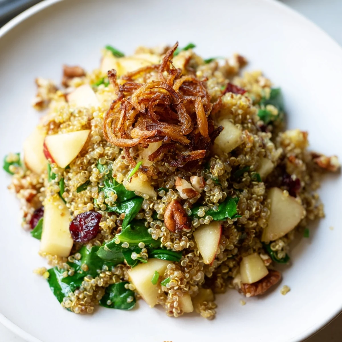 A close-up of Honey Mustard Quinoa Apple Salad featuring bright cranberries and toasted pecans