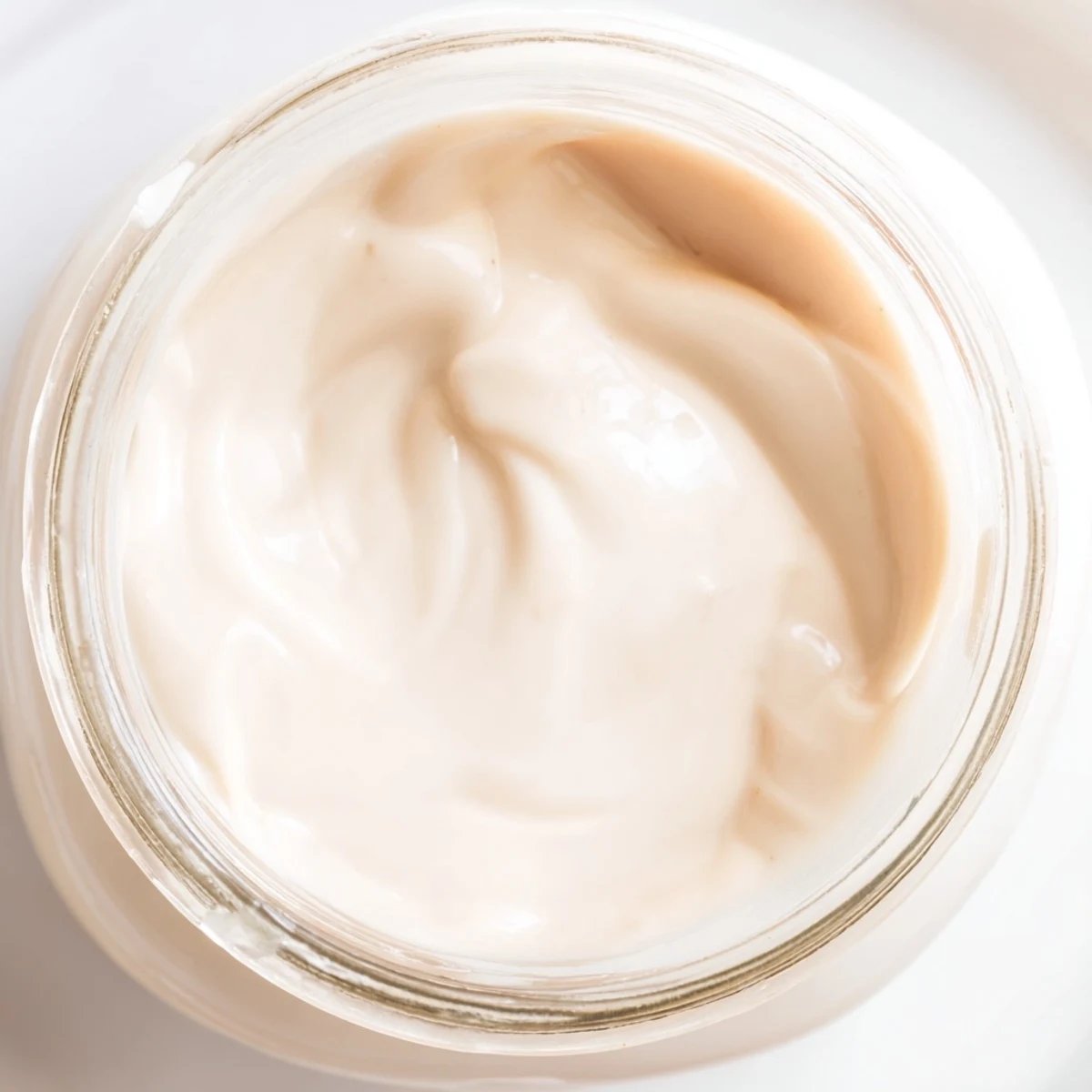 Thick golden condensed coconut milk drizzling off a wooden spoon