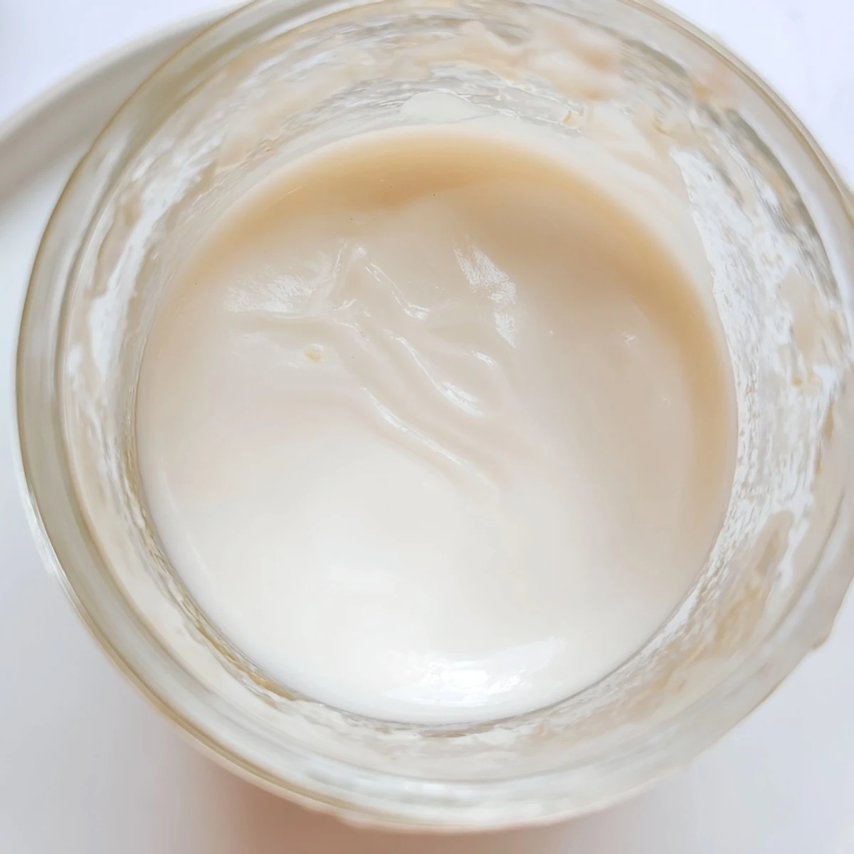 Velvety condensed coconut milk simmering in a saucepan on the stove
